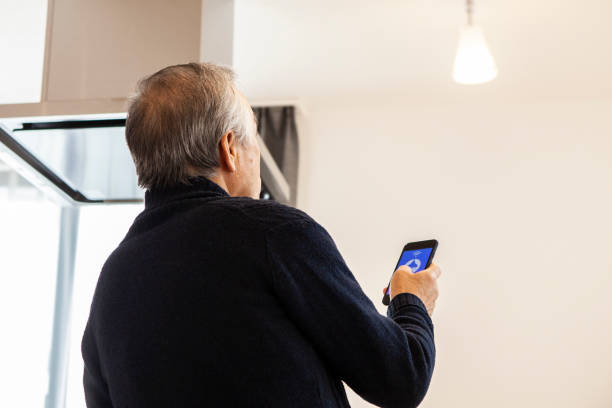 istock A senior man turns on lights and electricities by using a digital gadget, smart home appliances 1397007642
