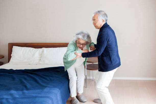 istock An Asian senior man caring for his wife getting up from bed. 1397007675