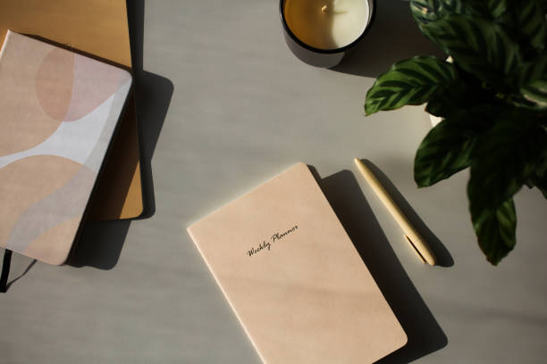 istock Aesthetic feminine workspace with weekly planner, notebooks, pen, candle, green plant on table. 1397008688