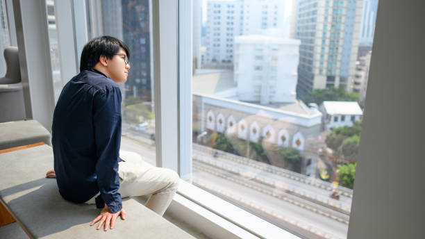 istock Asian man looking outside in office building 1397010153