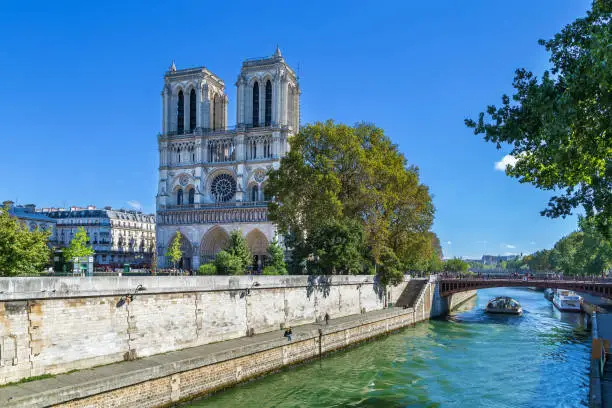 Notre-Dame de Paris is a medieval Catholic cathedral in Paris. View of cathedral facade from Seine bridge