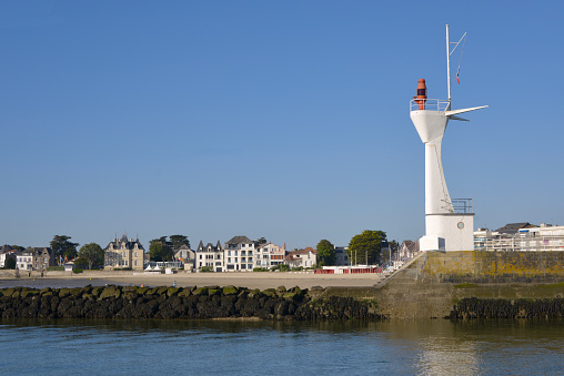 Modern lighthouse of Le Pouliguen seen from the side of the La Baule in Pays de la Loire region in western France. Le Pouliguen is a seaside resort on the famous Côte d'Amour for its fishing port \nand marina