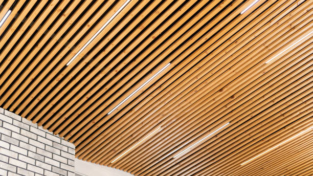 istock Close-up on a loft-style pine wood plank ceiling combined with white brick wall trim. The idea of ââa ceiling design in a minimalist style. Original LED strip lamps on the wooden ceiling. 1397012412