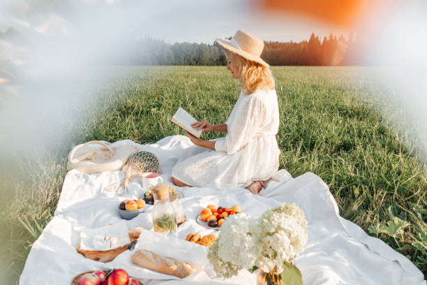 istock Woman read book on picnic in field. 1397012586