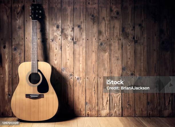 Acoustic Guitar Against Blank Wooden Plank Panel Grunge Background With Copy Space Stock Photo - Download Image Now