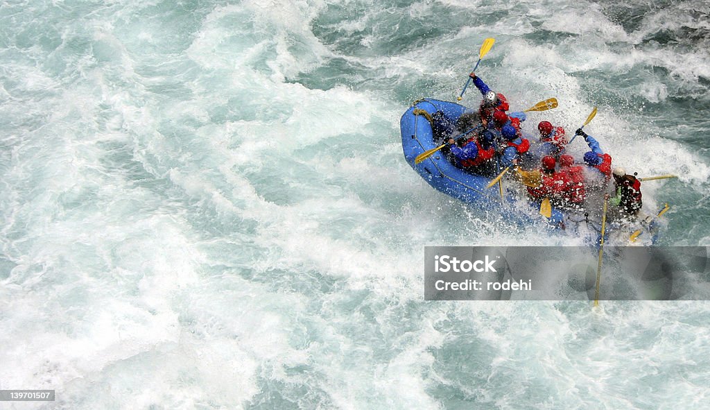 People in a blue inflatable boat river rafting chilko river british columbia/river rafting Teamwork Stock Photo