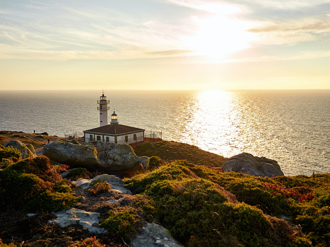 View of a beautiful sunset next to a lighthouse on the Normandy coast in France.