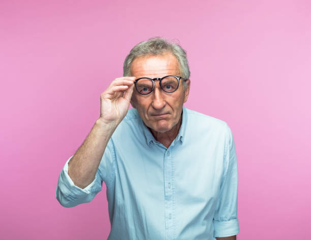 istock Senior man with serious face holding eyeglasses 1397019469