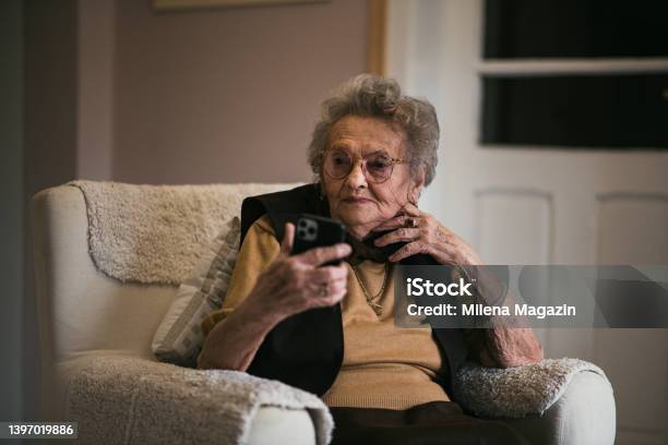 90 Year Old Lady Relaxing At Home Using Iphone Stock Photo - Download Image Now - Video Call, Happiness, One Woman Only