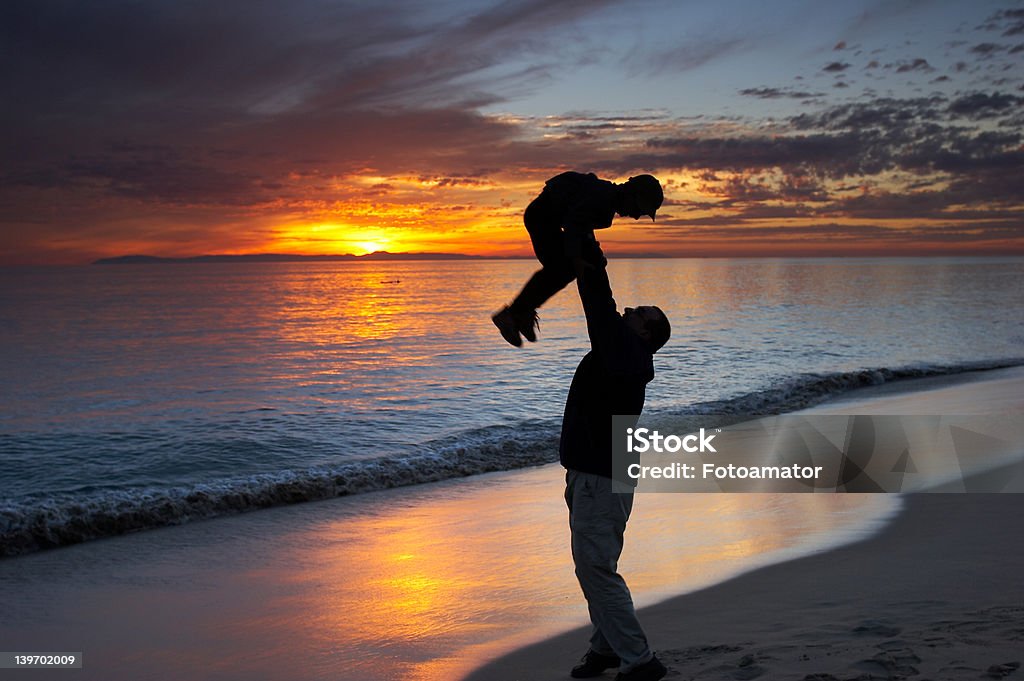 Father and son II Father and son playing together on a beach at sunset Active Lifestyle Stock Photo
