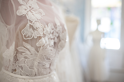 Beautiful white wedding dress on a dressmaker's model in bridal shop