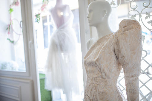 Beautiful white wedding dress on a dressmaker's model in bridal shop