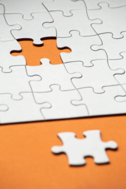 istock diagonal view of a jigsaw puzzle with a remaining piece on an orange background, completing a task or solving a problem concept. selective focus. copy space 1397020689