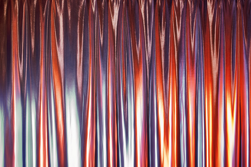 Smooth glossy abstract draped background in neon light. Neon red-blue wave.