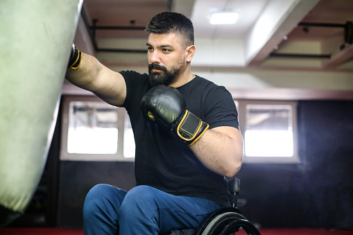 Disabled young man exercising boxing in a gym. About 30 years old, Caucasian male.