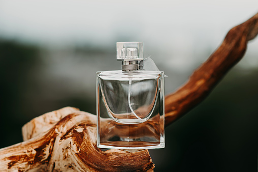 Glass bottle for perfume on a blurred background