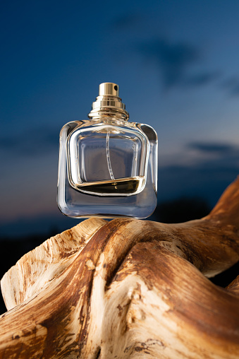 Glass bottle for perfume on dark sky background