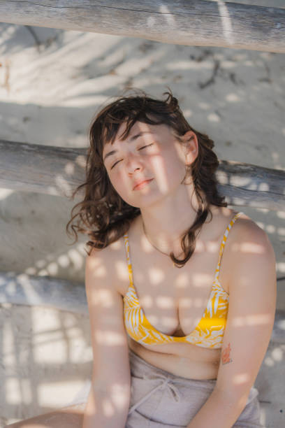 istock Woman sitting on sand on the beach under the palm tree 1397023309