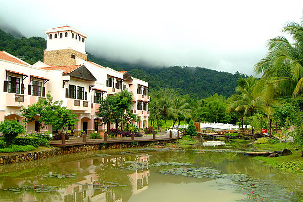 Palm tree and bungalow on Pantai Cenang, the most popular beach on the Langkawi island along the Andaman sea in Malaysia Kedah state.