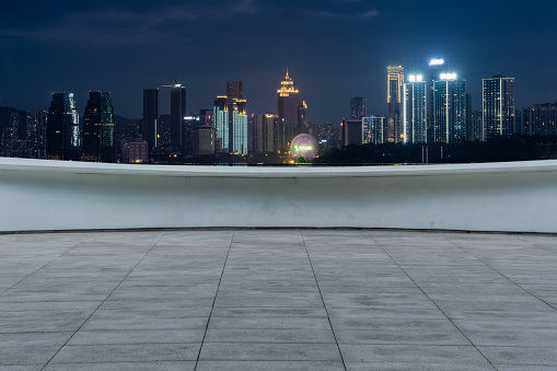 empty marble ground with modern cityscape at night