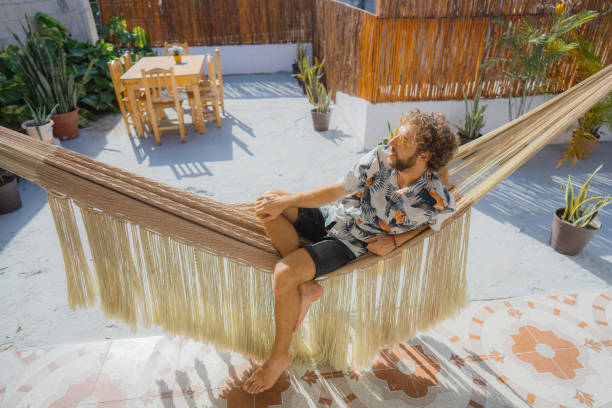 istock Man in Hawaiian shirt laying in hammock 1397023582