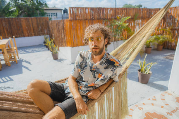 istock Man in Hawaiian shirt laying in hammock 1397023585