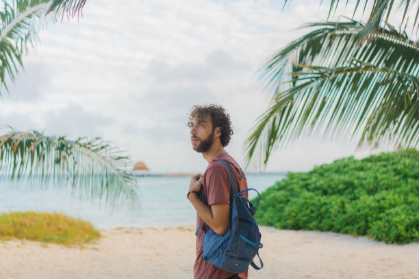 istock Man with backpack walking to the sea on Isla Mujeres beach 1397025130