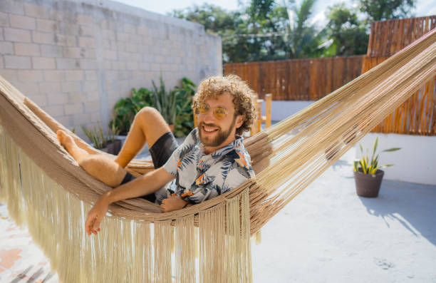 istock Man in Hawaiian shirt laying in hammock 1397025227