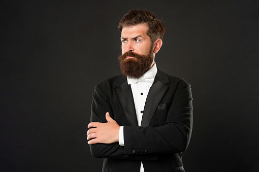 bearded bridegroom in tuxedo on black background, fashionist.
