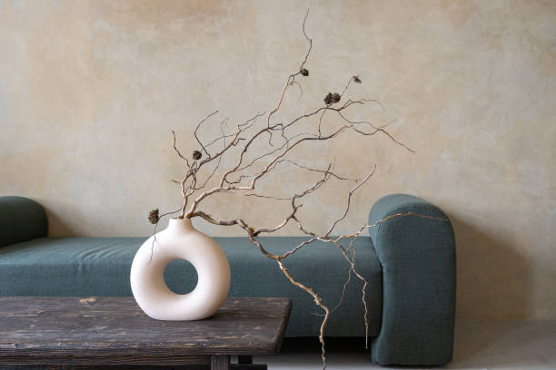 Dry branches in ceramic vase on vintage table Closeup of ceramic vase with dry branches on ancient table. Room with textured walls and decor interior design. Home comfort. Photo studio zone feng shui photos stock pictures, royalty-free photos & images