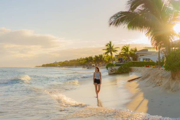 istock Woman walking on the beach at sunset 1397026508