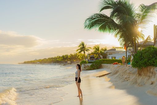 Young Caucasian woman walking happily on the beach in Tulum, Mexico