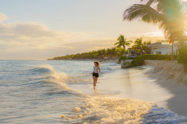 Woman running on the beach at sunset stock photo