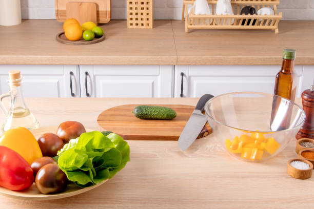 istock spread out on part of a modern kitchen with various items for cooking. a large dish with vegetables, a cutting board with a knife and a salad bowl. 1397026684