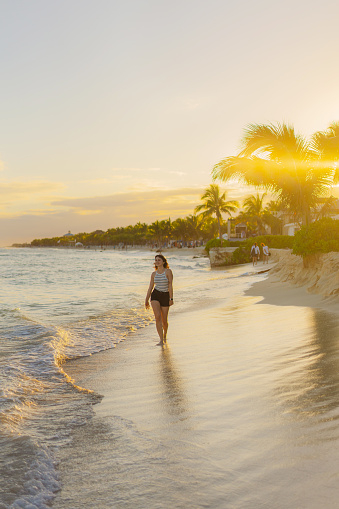 Young Caucasian woman walking happily on the beach in Tulum, Mexico