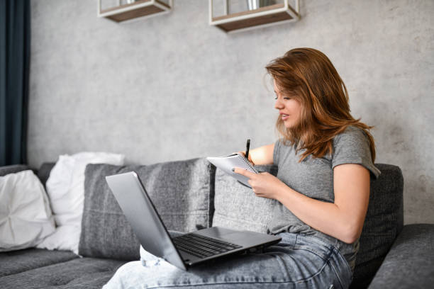istock Beautiful Female Studying With Laptop And Notebook At Home 1397031097