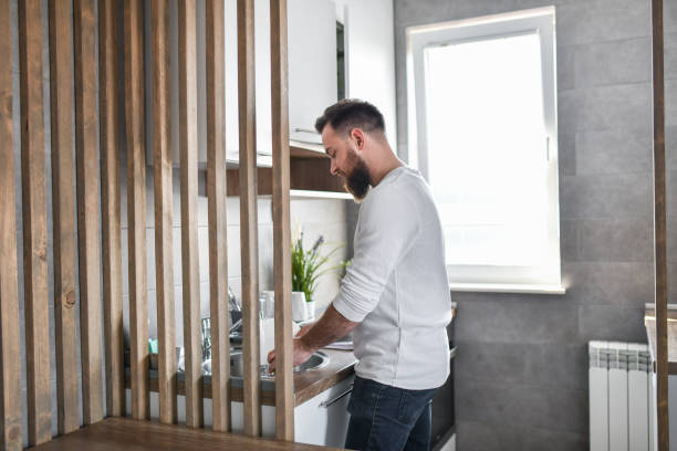 istock Bearded Male Focused While Washing Dishes At Home 1397031262
