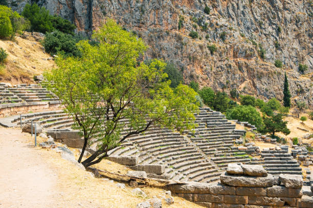 ギリシャのデルファイ遺跡にある古代円形劇場を背景にしたオリーブの木 - apollo greek god ancient greece greek culture ストックフォトと画像