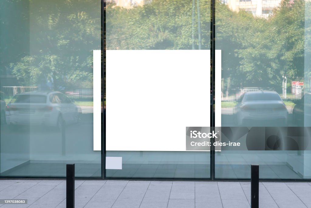 Blank white advertising poster in the shopwindow Store Window Stock Photo