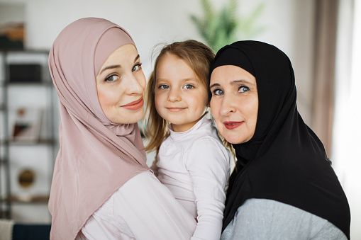 Muslim grandmother, daughter and grandchild together at home, happy domestic life moments. Family having fun, concepts about elderly, mult-generation islamic family and relationship