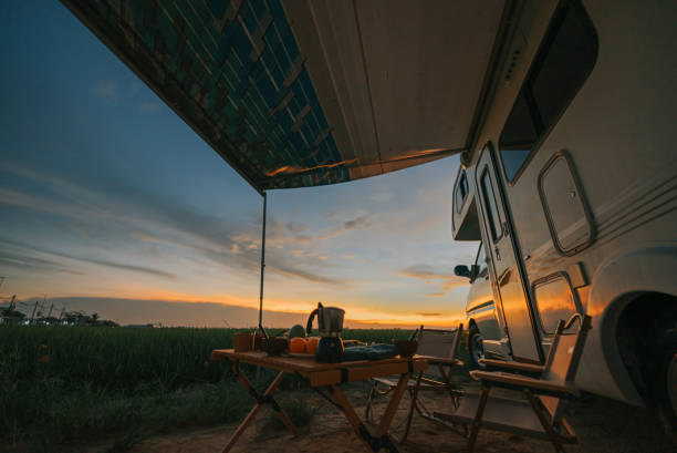 Motor home campervan park at rice paddy field during sunset