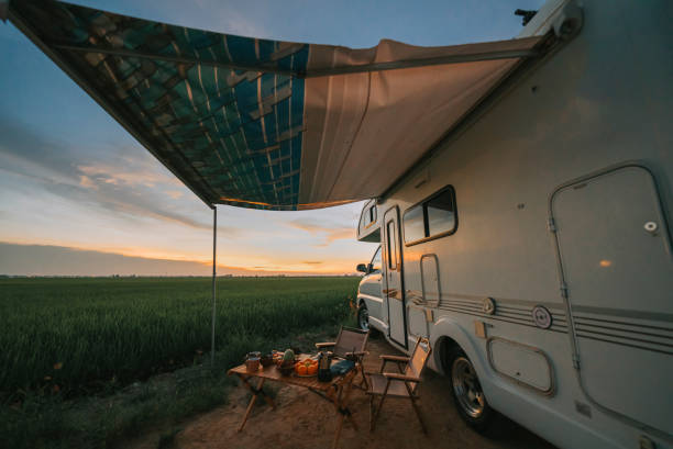 Motor home campervan park at rice paddy field during sunset