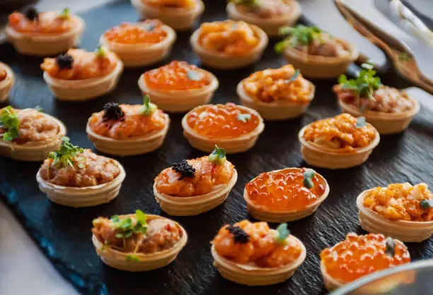 Tartlets with various filling on the buffet line. Shallow depth of field.