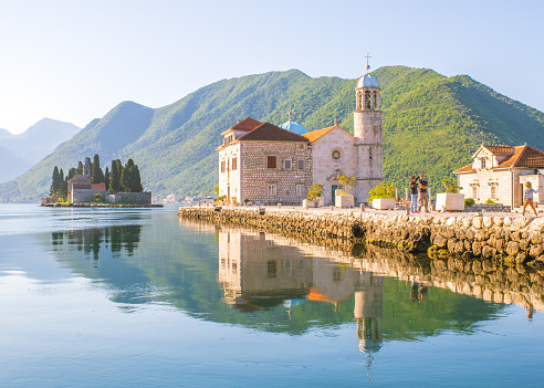 A picture of Kotor bay taken at the sunrise with a view on the Lady of the Rock