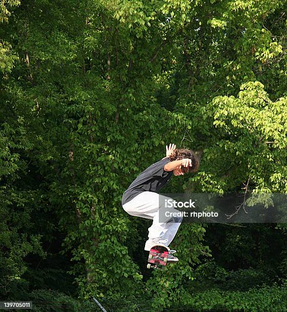 Skateboarder Jumping Near Trees Stock Photo - Download Image Now - 14-15 Years, 16-17 Years, Activity