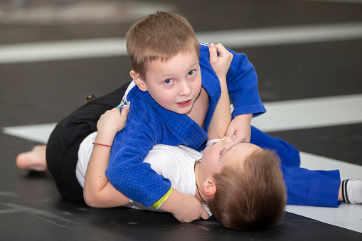 udo school for children. Funny little judoists make a throw.