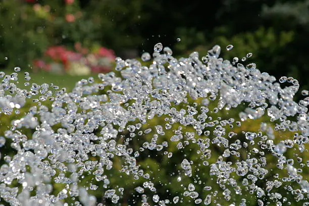 Photo of a water fountain in fast motion. These drops of water are seen by the human eye as a single stream.