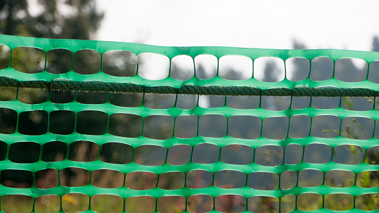 Green plastic net fence in field