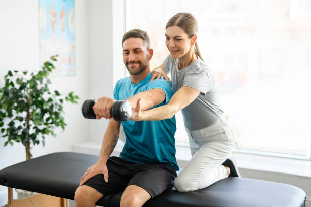 moderne rehabilitation physiotherapie arbeiterin mit mann klient - physiology stock-fotos und bilder