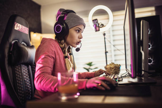 Girl plays video game online and streaming   at home Girl plays video game online and streaming   at home gaming chair photos stock pictures, royalty-free photos & images